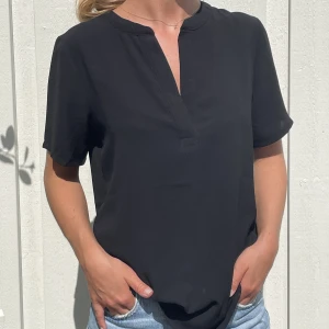 Blis - En svart blus med vringning 
