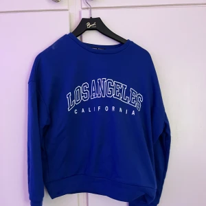 Blå sweatshirt  - Blå långärmad tröja med text💙Inte använd någon gång. Tröjan är i storlek M men är aningen liten i storleken och kan upplevas som S.