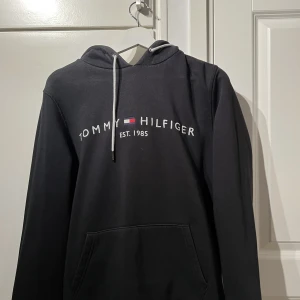 Svart Tommy Hilfiger Hoodie - Använd max 5 gånger på 2 år… Perfekt skick.