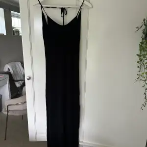Jag säljer denna oanvända klänning ifrån Behrska. Den är lång med en lätt v ringning framtill och öppenrygg med en snörning. Superfin och otroligt skönt material!