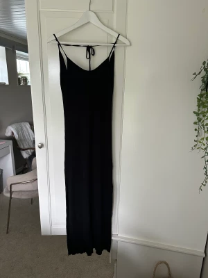 Långklänning - Jag säljer denna oanvända klänning ifrån Behrska. Den är lång med en lätt v ringning framtill och öppenrygg med en snörning. Superfin och otroligt skönt material!