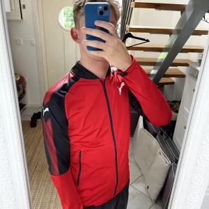 Röd puma ziptröja - En röd snygg ziptröja som funkar bra främst för träning men även till vardags. Helt oanvänd så skicket är 10/10 och mycket bra kvalite.