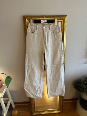 Cremefärgade jeans - Cremefärgade stretchiga jeans med vida ben. De är halvhöga i midjan. Använda då ggr så i jättefint skick.