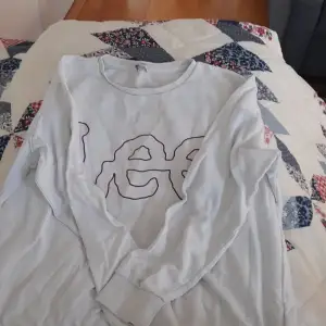 En vit långärmad tröja med texten Lee