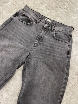 Grå jeans  - Gråa jeans som är slitna nere vid fötterna. Jag köpte byxorna här på Plick men dom är tyvärr för stora för mig. 