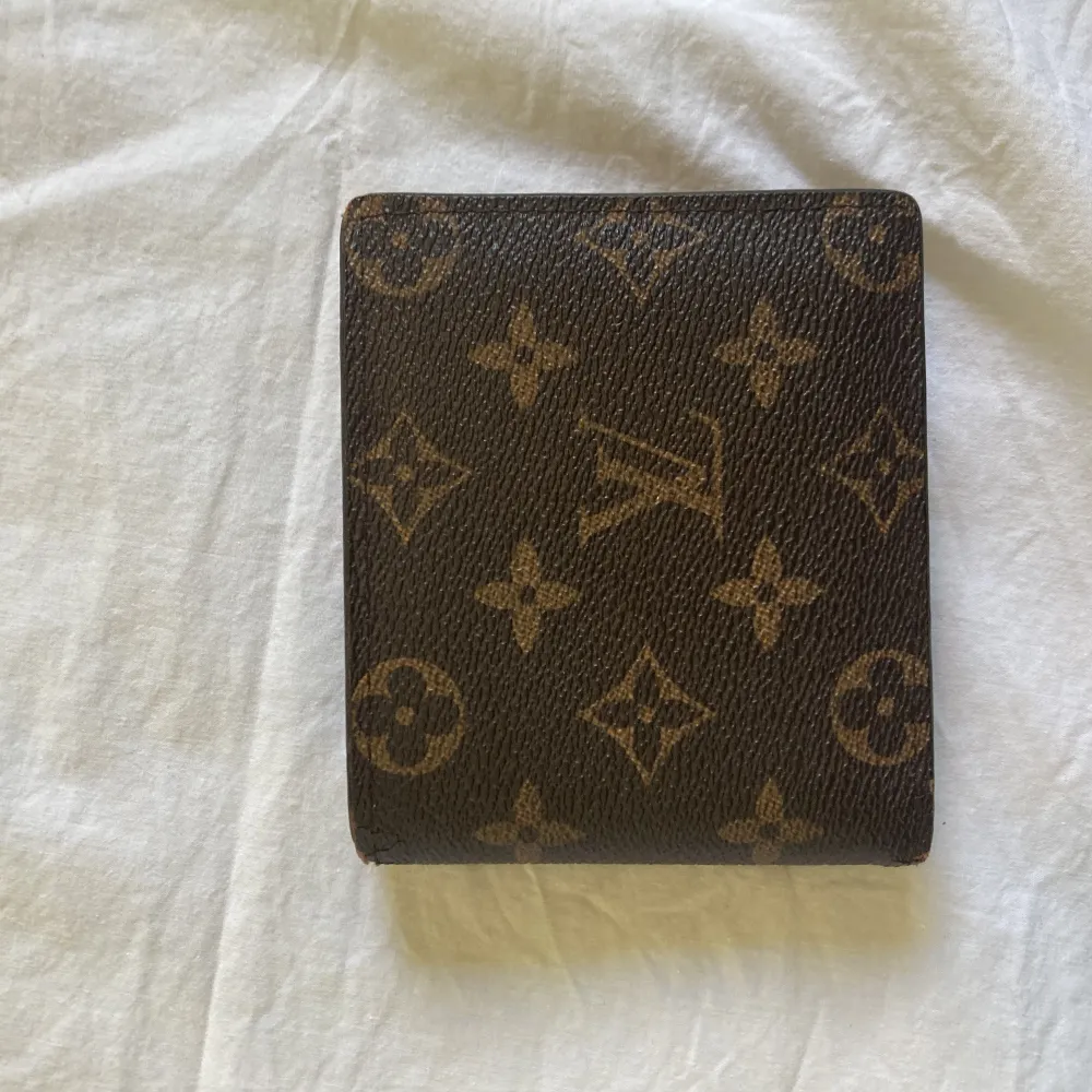 Louise Vuitton plånbok med två stora fack för sedlar, 3 fack för kort, ett till fack bakom korten och ett fack för mynt som har en knapp där man kan stänga. . Övrigt.