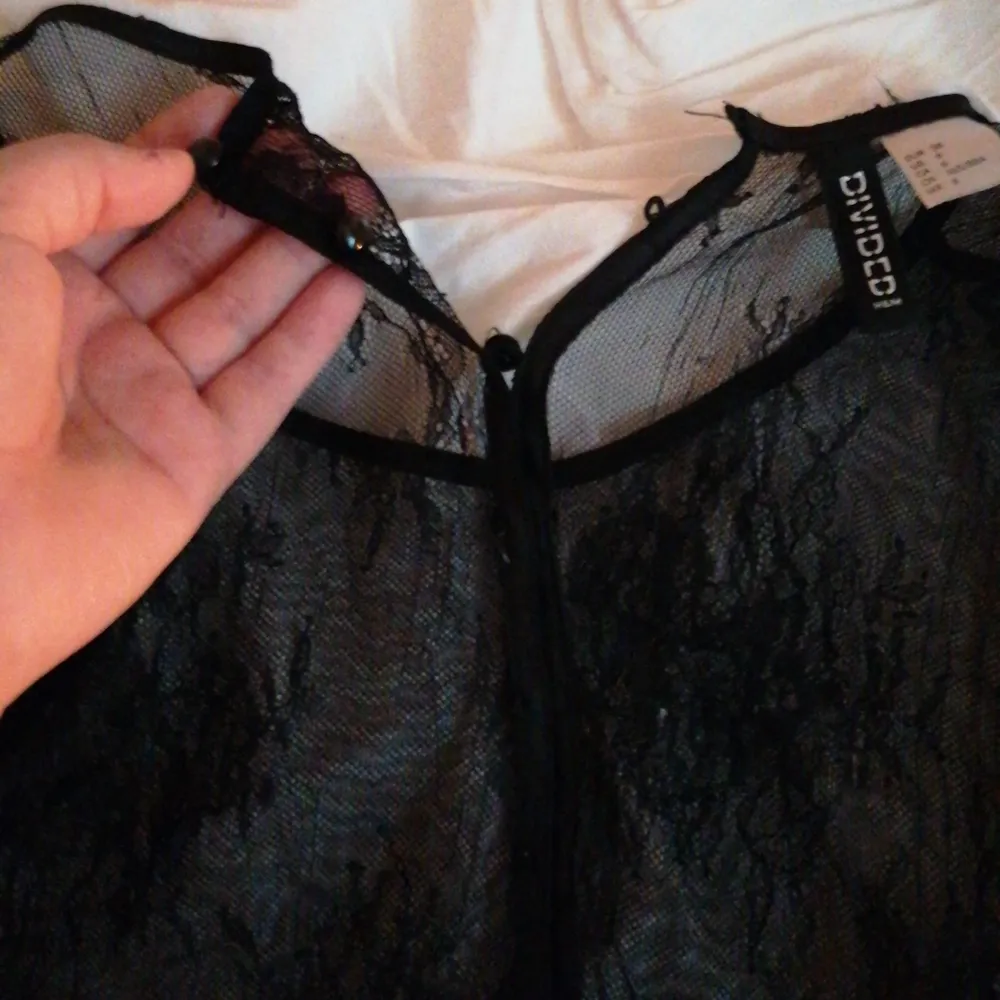 En svart mesh magtröja från H&M i storlek 38. Denna är också några år gammal och har ett hål i sidan men annars är hela helt hel. Det är knappar hela vägen ner där bak. . Yläosat.