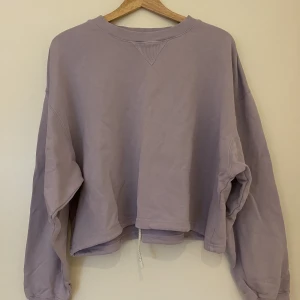 Lila sweatshirt  - Lila sweatshirt som har snöre att dra åt med i midjan.