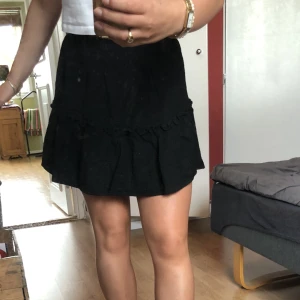 Svart kort kjol - Svart kjol med lite volang detaljer 