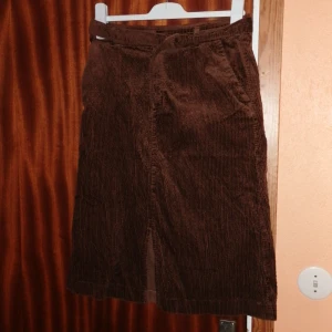 Brun kjol som går över knäna och ingår med skärp - En brun kjol som går över knäna i storlek 40 och skärp som ingår i kjolen. Den är från Kappahl och har använts ett fåtal gånger och knappen är väldigt lös. De passar fortfarande mig men har inte använt den på något år. ^^