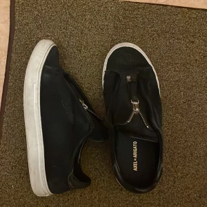 Axel arigato sneakers - Axel arigato zip skor i mocha, väl använda skor så de är lite nopprig. Med impregnering och mochaborste går de nog att fixa! Samt vatten och diskmedel på det vita. 
