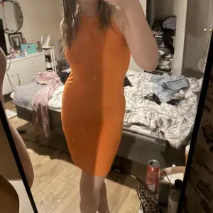 Orange klänning , öppen där back med Knyt runt halsen. Står inte vilken storlek men den är stretchig så skulle säga att den passar xs- M 