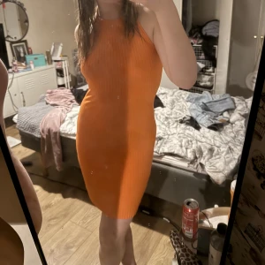 Orange klänning  - Orange klänning , öppen där back med Knyt runt halsen. Står inte vilken storlek men den är stretchig så skulle säga att den passar xs- M 
