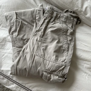 Bershka cargobyxor - Säljer ett par cargobyxor från Bershka, använda 1 gång, i fint skick.  Storlek 34, justerbara band i midjan. (Namnet är justerbara raka cargobyxor). Nypris: 379kr Mitt pris: 150kr
