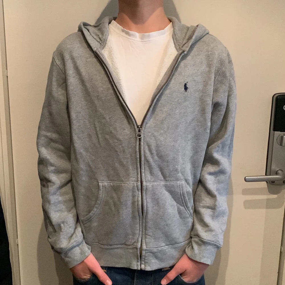 Ralph Lauren zip hoodie i använt skick utan några större defekter. Säljer då jag inte gillar hur den sitter runt midjan. Modellen på bilden är nästan 170cm.. Hoodies.