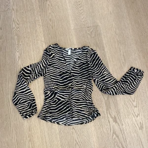 Svart/beige topp - Figursydd, smått ballongarmar. 