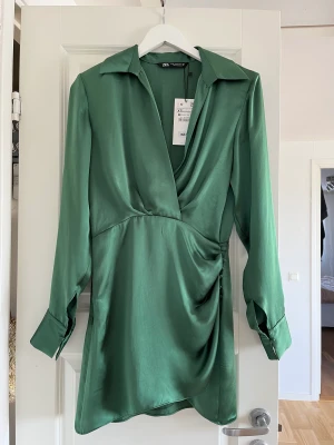 Olivgrön klänning - Härlig satinklänning från Zara, fortfarande med lappen kvar! Köpare står för frakt, kan mötas upp i Malmö/ Lund!