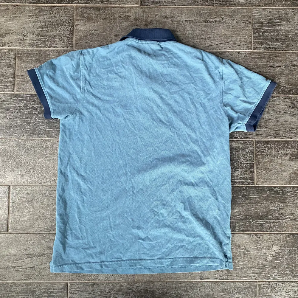 En blå pikétröja i storlek M men sitter som en S. Den är i bra skick och inte använd mycket. T-shirts.