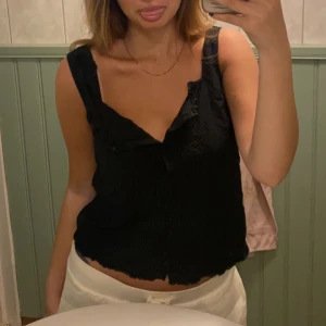 Svart topp - Flyttrensar och säljer denna super söta svarta topp, går så fint ihop med ett par lågmidjade byxor 