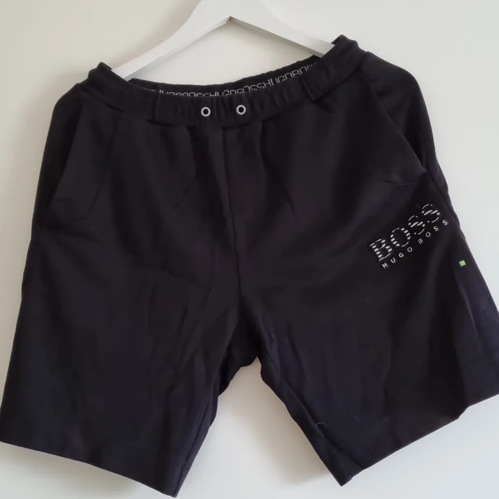 Svarta shorts med silvriga/grå detaljer, reflekterande. Fint skick men snöre saknas.. Shorts.