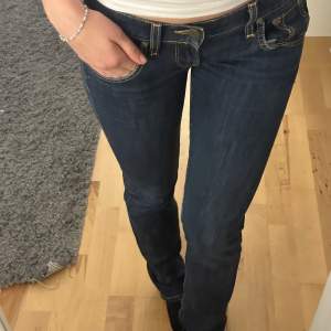 Blåa lågmidjade jeans stl 25/33 från märket Lee. Är 165 cm lång och jeansen nuddar hälarna. Köpta second hand men är i nyskick!