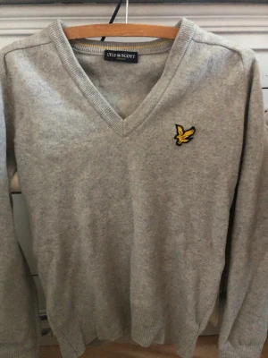 LYLE & SCOTT xs - En tröja i stl XS.. Från axeln till ärmen är det ca 60cm Den är i 100 ull.  Färgen är ljusgrå. Pris 400 eller förslag.  Endast postnord & swish.   