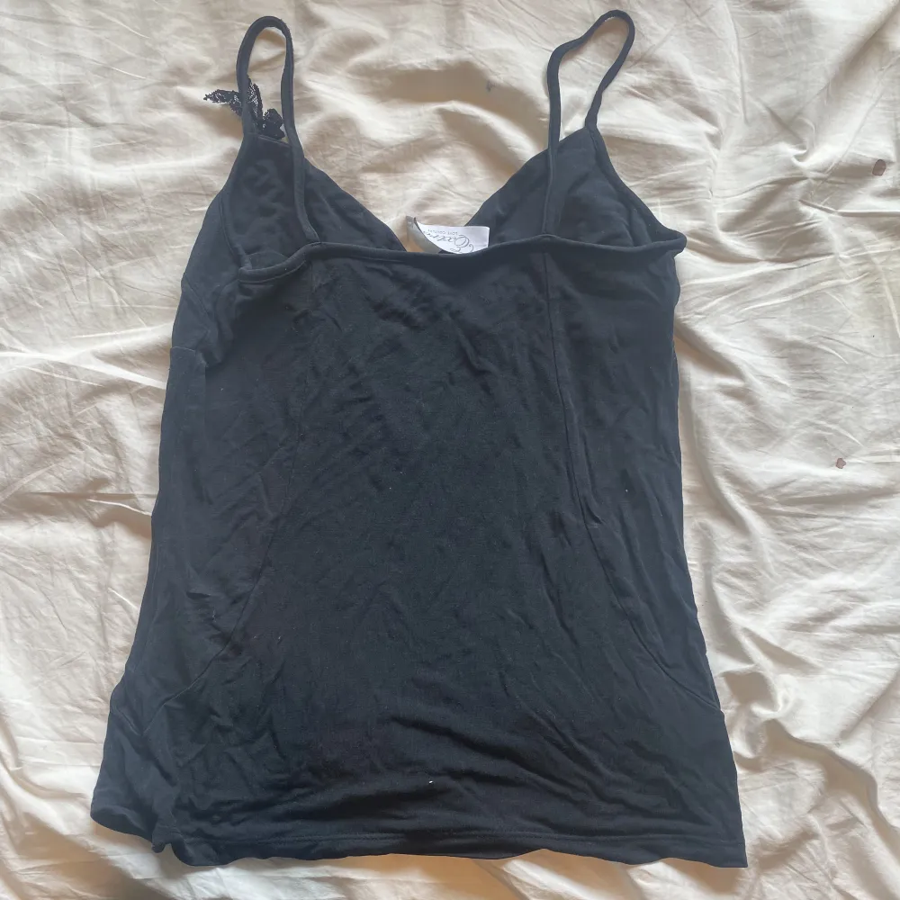 Black tank top with cute bow on the right that is in great condition. /Svart linne med söt rosett till höger som är i jättefint skick.. T-shirts.