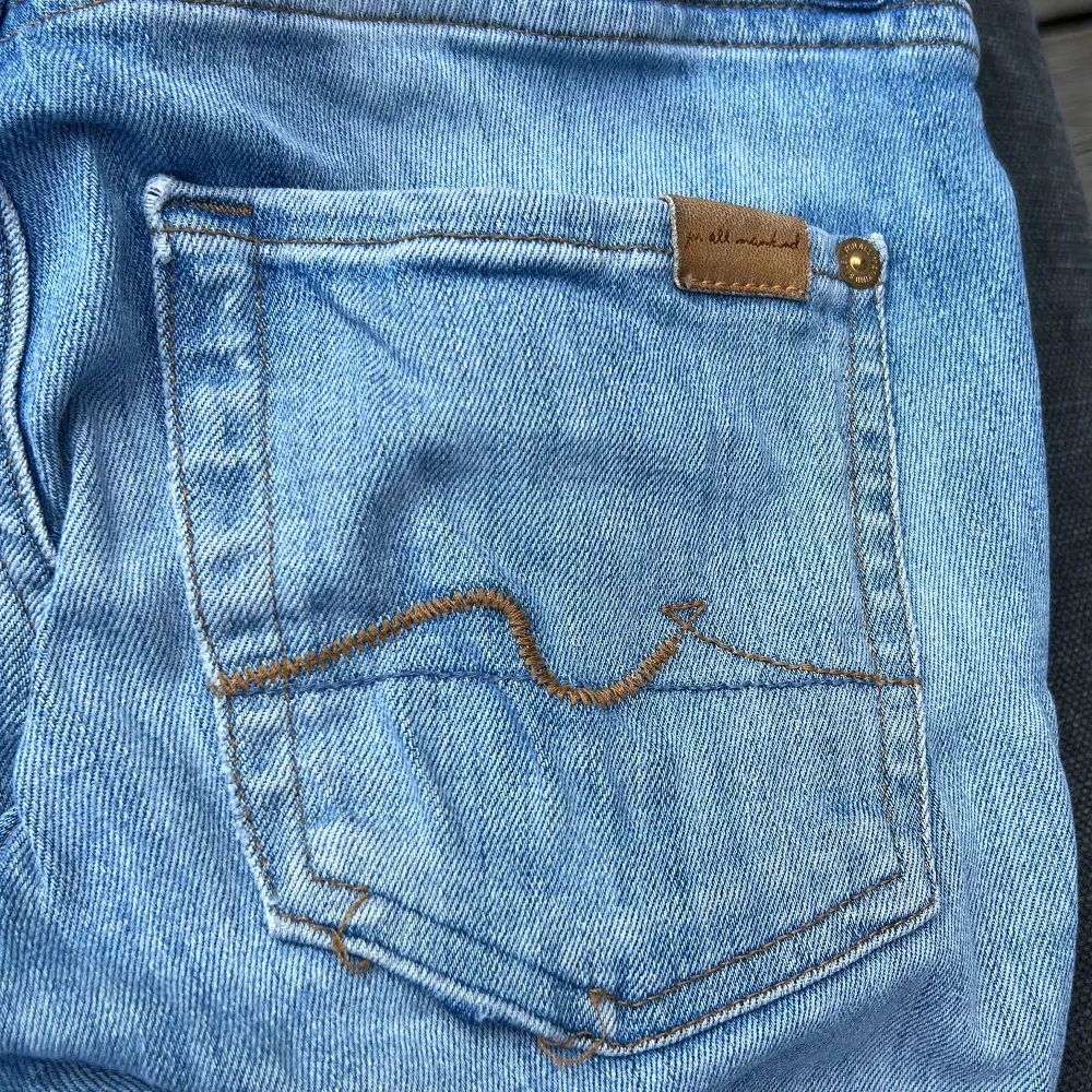 Raka seven jeans med låg midja i strl 23. Supersnygg slitning. Sömnen har släppt på ena fickan, enkelt fixat med en symaskin. Strl passar en 25. . Jeans & Byxor.