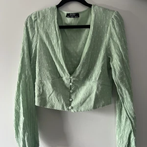 Fin blus/topp BERSHKA - En superfin ljusgrön blus/topp ifrån bershka storlek L, dock är den för liten för mig och jag skulle säga att den passar mer S/M. Säljs för att den aldrig använts pga storleken. Går att klä upp och klä ner!💚