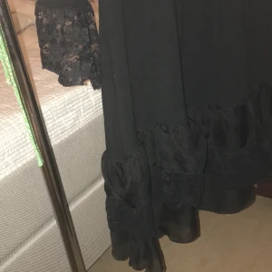 Svart kort klänning   - Simpel långärmad/kort svart klänning, med volanger på underdelen och vid ärmarna. Välldigt fin på, är lite över knät typ på mig mig som är 174cm. Passar bra med tunna svarta strumpbyxor!Bra skick, inga hål eller något .💕😊👗