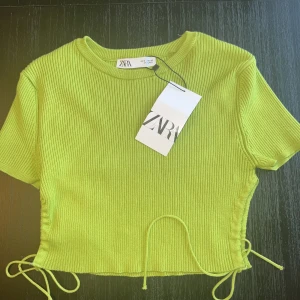 Croppad topp från Zara - Säljer en kroppad topp från Zara. Den är oanvänd och har kvar etiketten.
