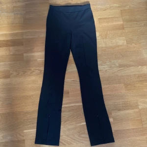 Bikbok byxor - Svarta högmidjade byxor från Bikbok i storlek S. Byxorna har en söm i mitten på varje byxben och dragkedja längst ner. Är i mycket fint skick. 