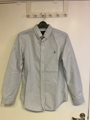 Randig Ralph Lauren Skjorta - Snygg somrig ralph lauren skjorta som blivit lite för liten. Storlek 16 förra säljarn sa att den passar medium men skulle säga small. Säljer pga den e för liten 👍👍
