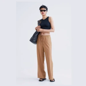 Lösa byxor med dragsko  - Lösa beiga byxor med dragsko, andra bilden är hur dom sitter på mig!:) (köpte storlek M för att få dom lite större, har storlek s/xs, beror hur man vill dom ska sitta!:)