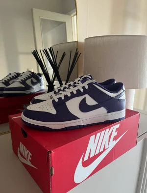 Nike dunk court purple  - Säljer ett par nike dunk court purple som jag fått på drop  Online kvitto finns  Size: 43 Cond 10/10 Bud: 1000kr