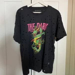 T-shirt  - T-shirt från Nelly, aldrig använd! Är oversized med hål över hela tröjan, frågan är väldigt mörkgrå