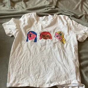 En vit T-shirt från zara med 3 färgglada ansikten på! 🤍🩵🩷