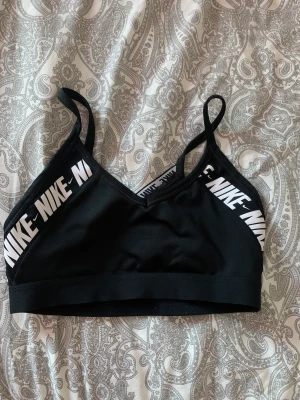 Sport-topp - Supersnygg sporttopp/ bh från Nike, fortfarande väldigt bra skick men har slängt padsen som låg i från början. Säljer pga växt ur den🥲. Den har genomskinlig rygg🥰