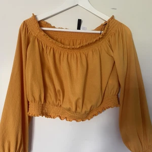 Topp - Gul topp i nyskick från H&M, storlek M. Använd 1 gång. Magtröja med resår i både armar och midja 