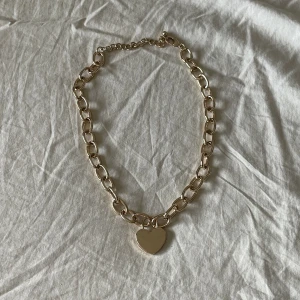 guldigt kedjehalsband med hjärta - Fint guldfärgat halsband från H&M, EJ äkta guld alltså!! Bra skick då det knappt använts :) Storleken är justerbar. kontakta mig om du har några frågor, annars använd "lägg prisförslag" <3