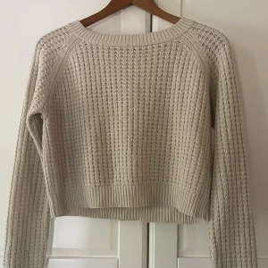 Stickad tröja.  - Beige stickad tröja. Kort modell. Av märket Mim och passar som XS. 