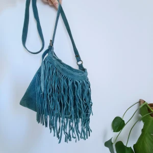 Läderväska med fransar - Superfin läderväska i turkos med bohemiska fransar. Jättefint skick! Lite ont att sälja men kommer inte till användning hos mig :)
