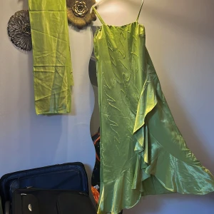 Balklänning  - Balklänning i sidenliknande tyg med paljetter och volanger på. Har även en extra sjal därtill. Skriv vid behov av fler bilder och priset kan diskuteras.