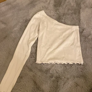 Vit enarmad tröja - En vit ribbad enarmad tröja.