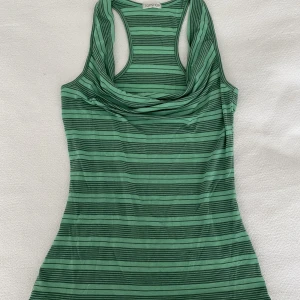 Randigt linne - Ett fint, randigt sommarlinne i grön/turkos färg. Är ganska långt och har en häftig urringning med lite extra tyg som viks ner. Sitter perfekt på mig som är S och passar väldigt bra nu till sommaren!!