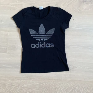 Svart t-shirt med adidas märke  - Använd i flera år men inte sönder eller sliten någonstans. Märket ganska slitet men det är det ändå. 