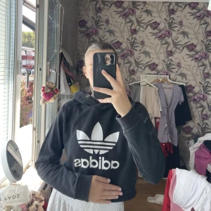 Adidas träningströja - En croppad träningströja från Adidas! Köpt för några år sedan! Super snygg och bekväm!!🖤 Storlek S!! Tröjan saknar snören vid luvan 🖤
