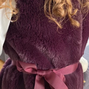 PompdeLux väst i storlek 146 - 152 tjej -  Fin pompdelux väst som är sparsamt använd. Västen är mörk lila,  innefodret är lilla och med vita prickar. Västen är fluffig och gosig passar till allt super snygg. Kommer med siden band.