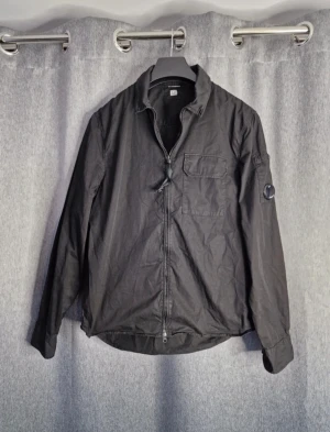 CP Company jacka - Snygg CP Company overshirt i storlek m nypris är ca 3000 mitt pris är 1500 glaset har en liten repa som syns på bilderna men det är inget som märks. Skriv självklart om du har fler frågor 