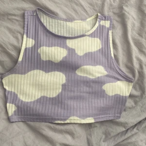 ljuslila topp - en söt liten croppad ljuslila topp med vita molnmönster. jag har haft den på mig några gånger men den är i bra skick. ganska croppad på mig dock och jag är 170cm. upplever att den är lite liten i storleken.